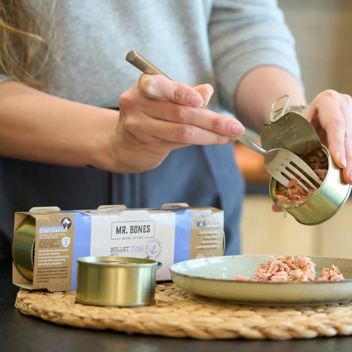 Hand tar tonfisk ur öppnad burk med gaffel