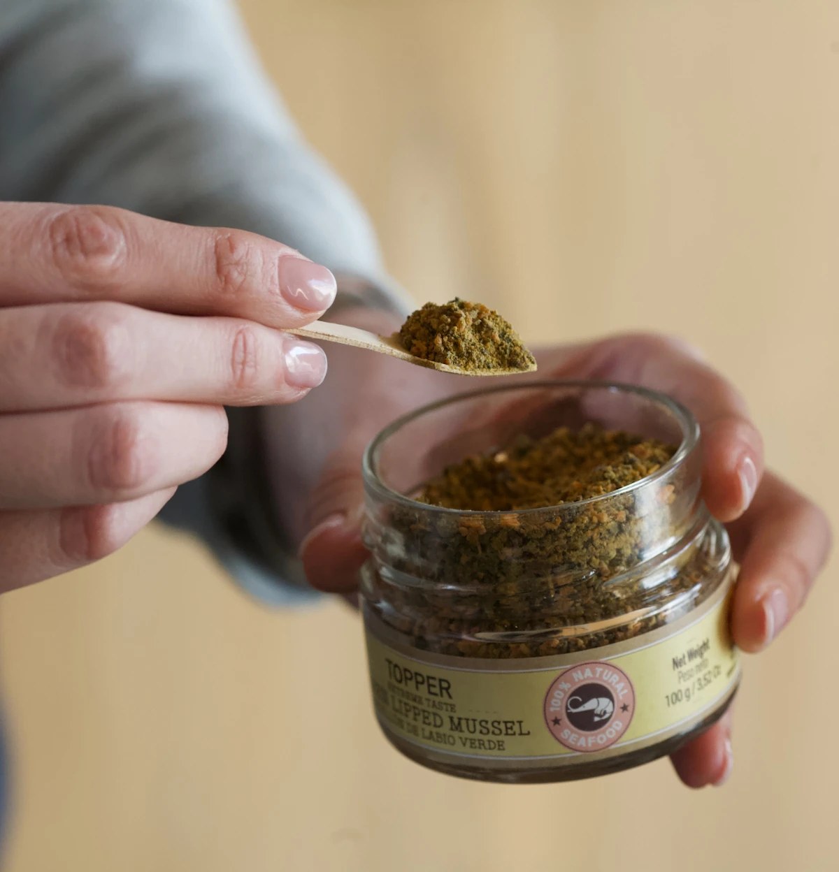 Sked med topper grönläppad mussla lyfts ur glasburk