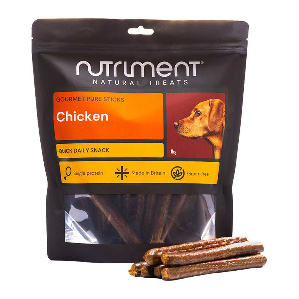 Nutriment Gourmet Pure Sticks Kyckling 1kg, stor svart påse med orange etikett och godispinnar framför, mot vit bakgrund