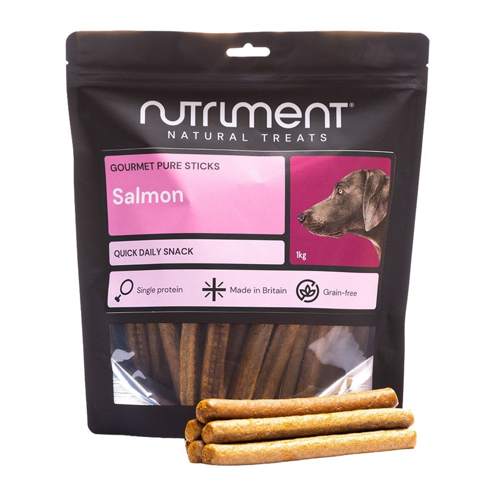 Nutriment Gourmet Pure Sticks Lax 1kg, stor svart påse med rosa etikett och godispinnar framför, mot vit bakgrund